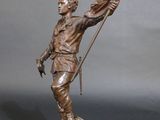 bronze statue of a man holding a flag on a wooden base