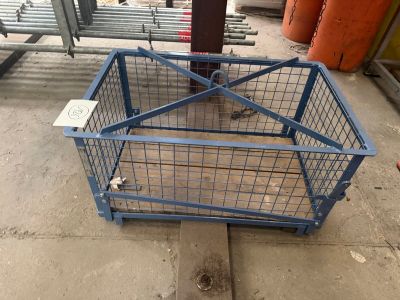 a cage that is sitting on the ground next to a pole