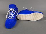 the sole of a pair of blue sued shoes with white laces