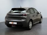 the back of a grey car in a room with a white wall
