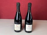 trois bouteilles de vin sont posées sur un comptoir devant un mur rouge