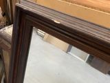 a large mirror sitting on a table next to a chair