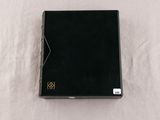 an open black book sitting on top of a white table