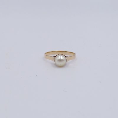 une bague en or avec une perle au centre