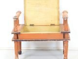 an old wooden chair with a wooden seat and a box on the back