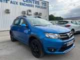 une Dacia bleue garée devant un immeuble, sur un parking