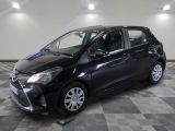 une Toyota Yaris noire garée sur un sol à damier dans un garage
