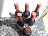 several bottles of wine are lined up on a marble table