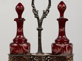 pair of red glass decanters on stand with ornate design
