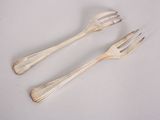 two forks and two spoons on a white table