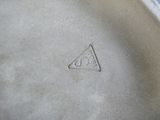 une assiette blanche sur laquelle est dessiné un triangle, posée sur une table