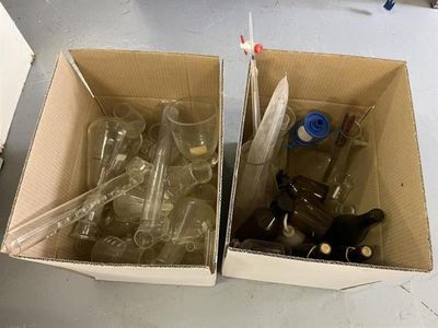 deux boîtes contenant des bouteilles vides, posées sur une table