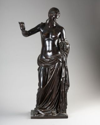une statue en bronze représentant une femme tenant une pomme à la main