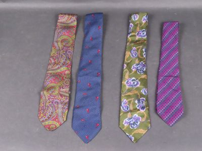 four different colored ties are lined up on a table