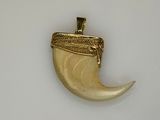 a gold plated pendant with a horn shaped object on it