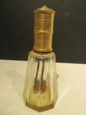 a small glass bottle with a gold top on a table