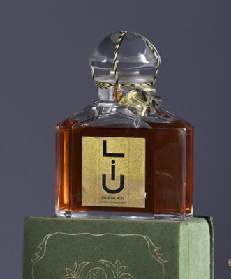 a bottle of perfume sitting on top of a green box