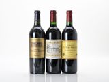 three bottles of wine are lined up on a white surface