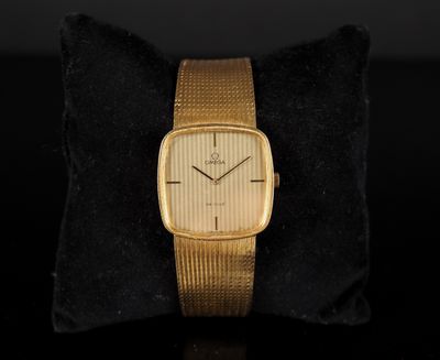 une montre en or posée sur un coussin noir, avec un oreiller noir