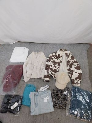 a lot of clothes and other items laid out on the floor