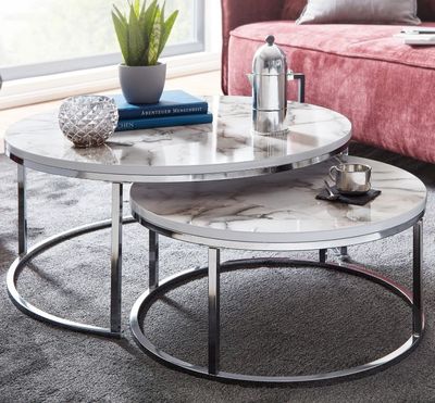 deux tables au plateau en marbre posées sur un tapis dans un salon