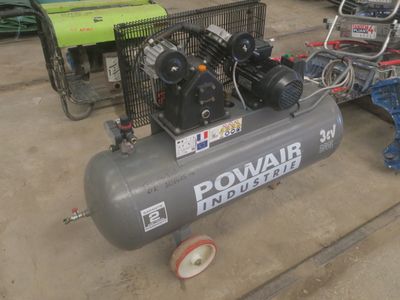 un petit compresseur d'air posé par terre à côté d'autres équipements