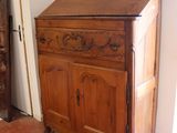 a wooden cabinet in the corner of a room with a door