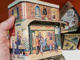 a person holding a tin box with a painting on it