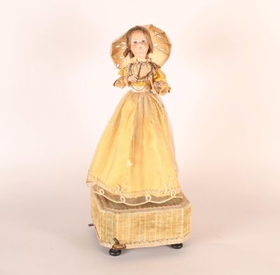 a doll that is dressed in a yellow dress and holding an umbrella