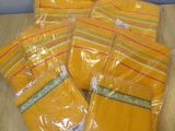 four bags of yellow plastic bags sitting on top of a wooden table