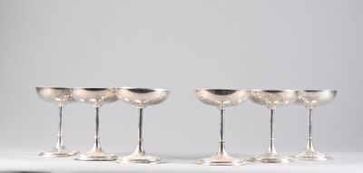 three silver wine glasses sitting next to each other on a table