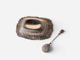an image of a silver plate with a spoon and spoon rest on it