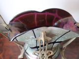 a glass vase with a metal handle on a table