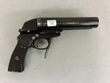 un gros plan d'un pistolet posé sur une table, avec une étiquette dessus
