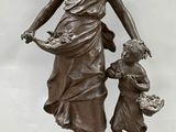 bronze statue of a woman with two children on a marble base