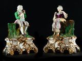 two figurines of a man and a woman sitting on top of a tree stump