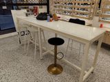 a white counter with two stools in front of it