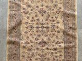 un tapis beige à motifs floraux et franges