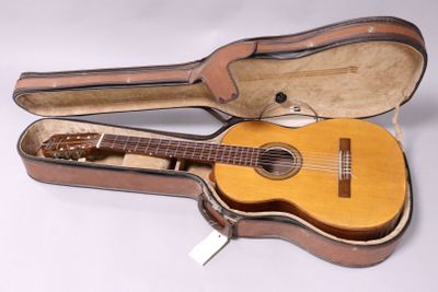 a guitar in a case sitting on a white surface