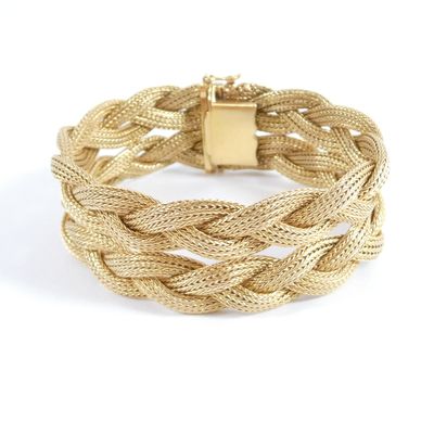 a close up of a gold bracelet on a white background