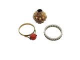 two rings and a ring with a red stone on a white background