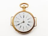 une montre de poche en or avec des chiffres romains sur le cadran