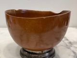 brown ceramic bowl sitting on top of a marble counter top