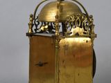 a gold clock with a bell on top of it