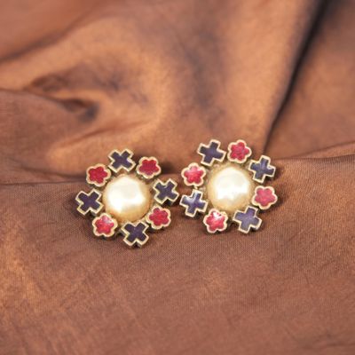 un gros plan sur une paire de boucles d'oreilles posées sur un tissu marron