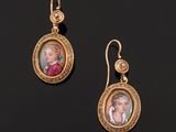an image of a pair of gold earrings with a portrait of a woman