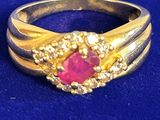 une image représentant une bague en or sertie d'un rubis entouré de diamants
