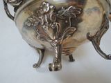 a silver bowl with a handle on a white table