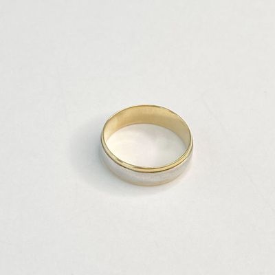 gros plan d'une bague en or sur une surface blanche