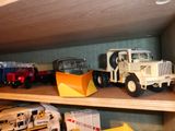 de nombreux camions miniatures posés sur une étagère dans une pièce